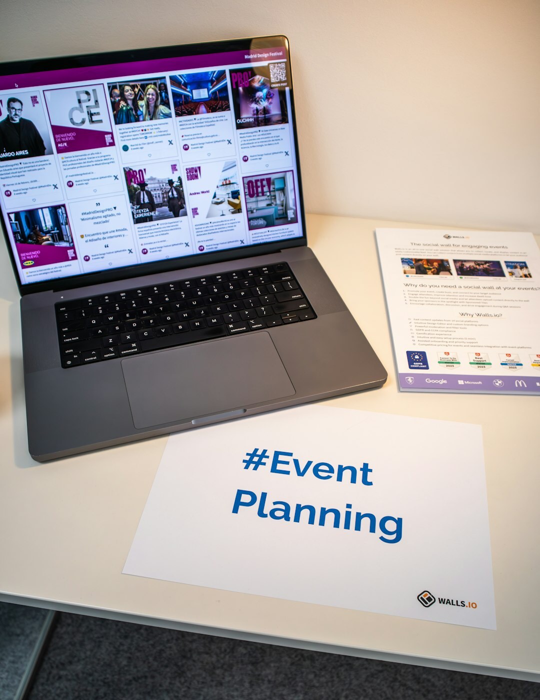Two colleagues planning an event on a laptop at a desk